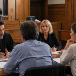 Réunion de conciliation au tribunal avec avocat et médiateurs autour d’une table